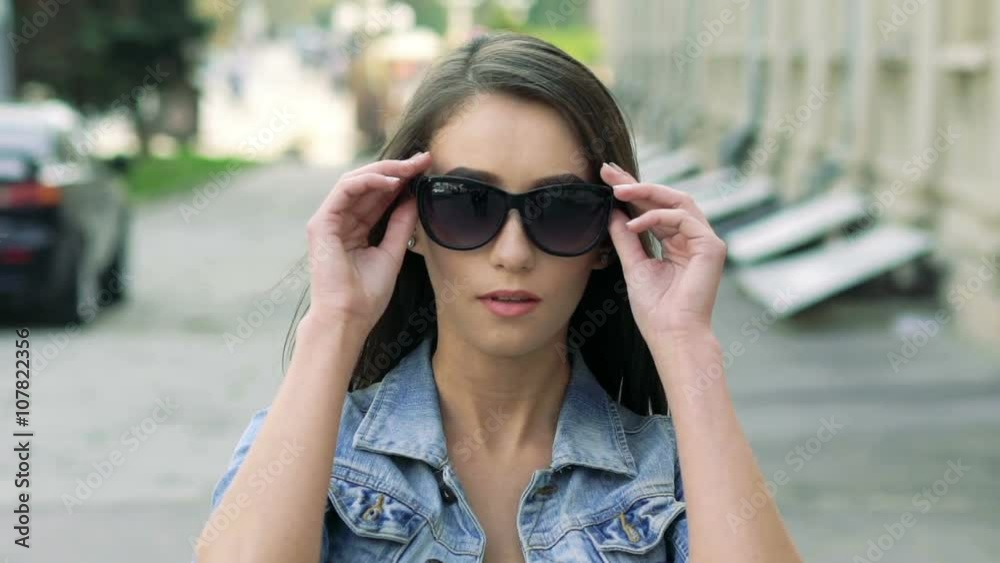 Pretty girl walking on camera and taking off sunglasses. Slowly Pretty girl walking on camera and taking off sunglasses. Slowly