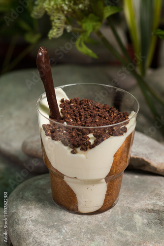 creamy chocolate dessert, sprinkled with chocolate chips in a glass, with chocolate spoon