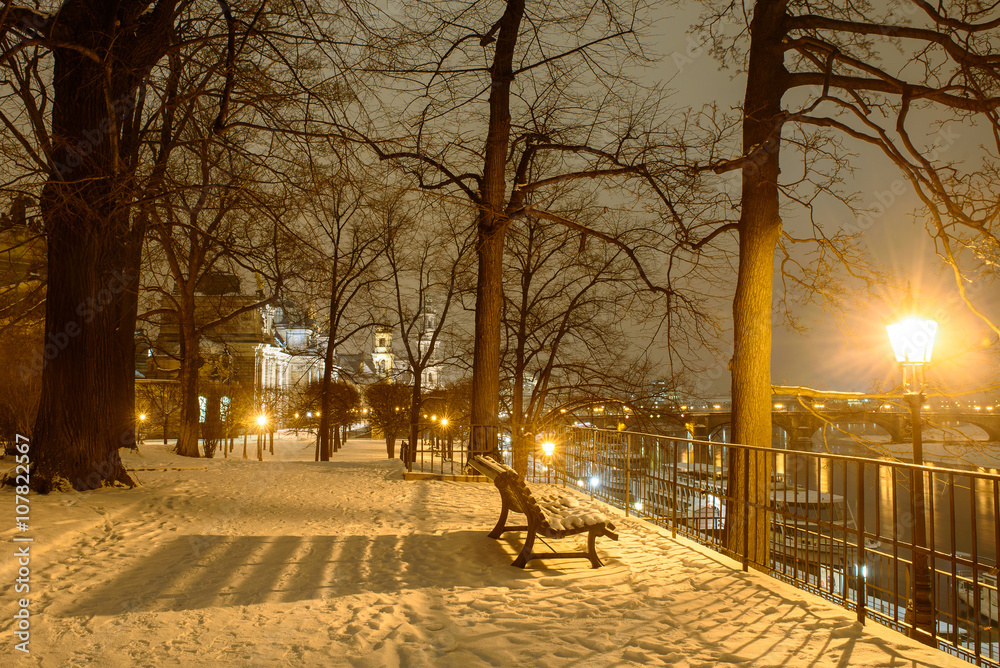 Bench on a snowy embankment in Dresden, Winter night