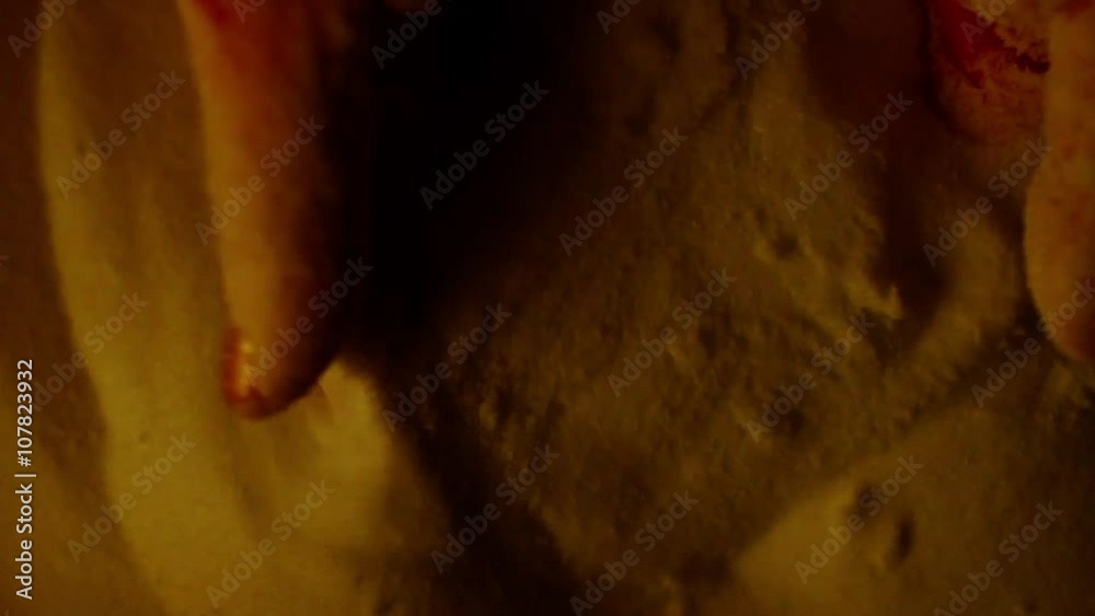 Fingers Raised Out of the Sand in a Bowl in Dim Lighting Fingers Raised Out of the Sand in a Bowl in Dim Lighting