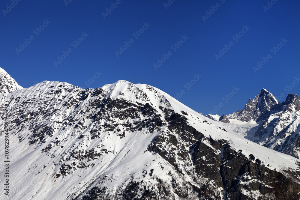 Snowy mountains and blue clear sky at nice sun day
