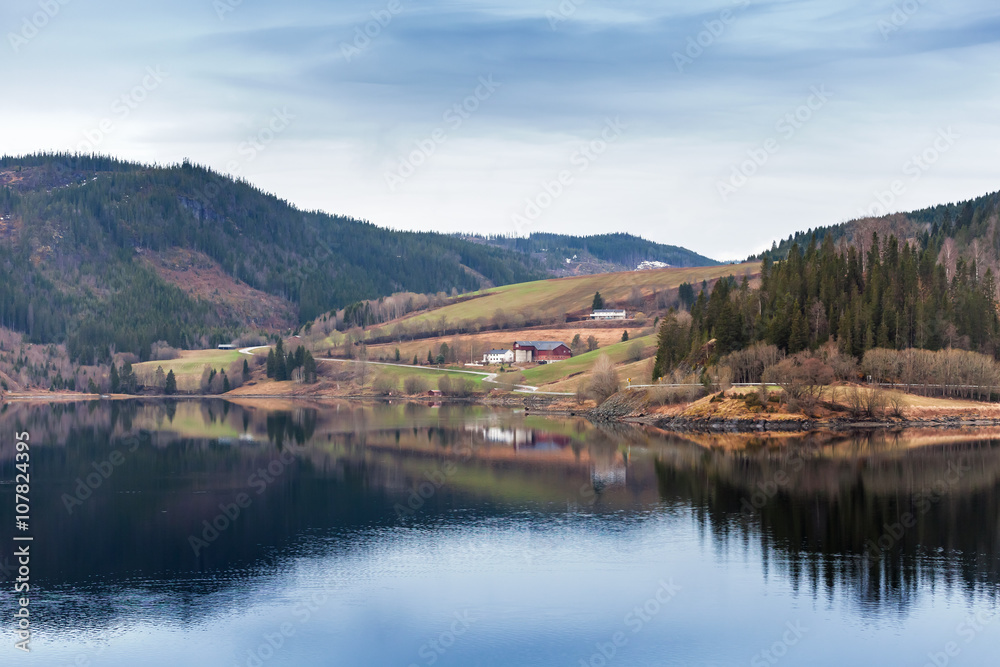 Rural Norwegian landscape with still lake water