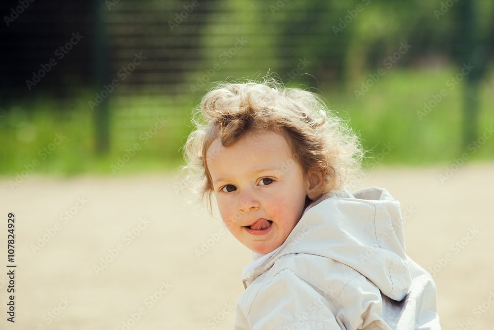 beautiful blond curly hair child play outdoor in a park beautiful blond curly hair child play outdoor in a park
