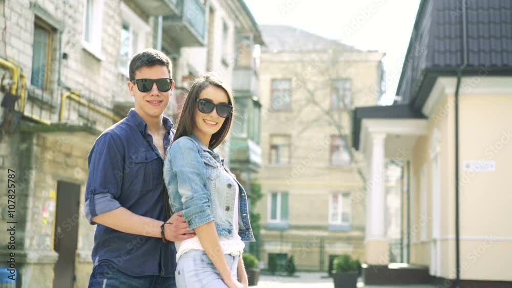 Lovely couple embracing and posing on camera on street background. 4k Lovely couple embracing and posing on camera on street background. 4k