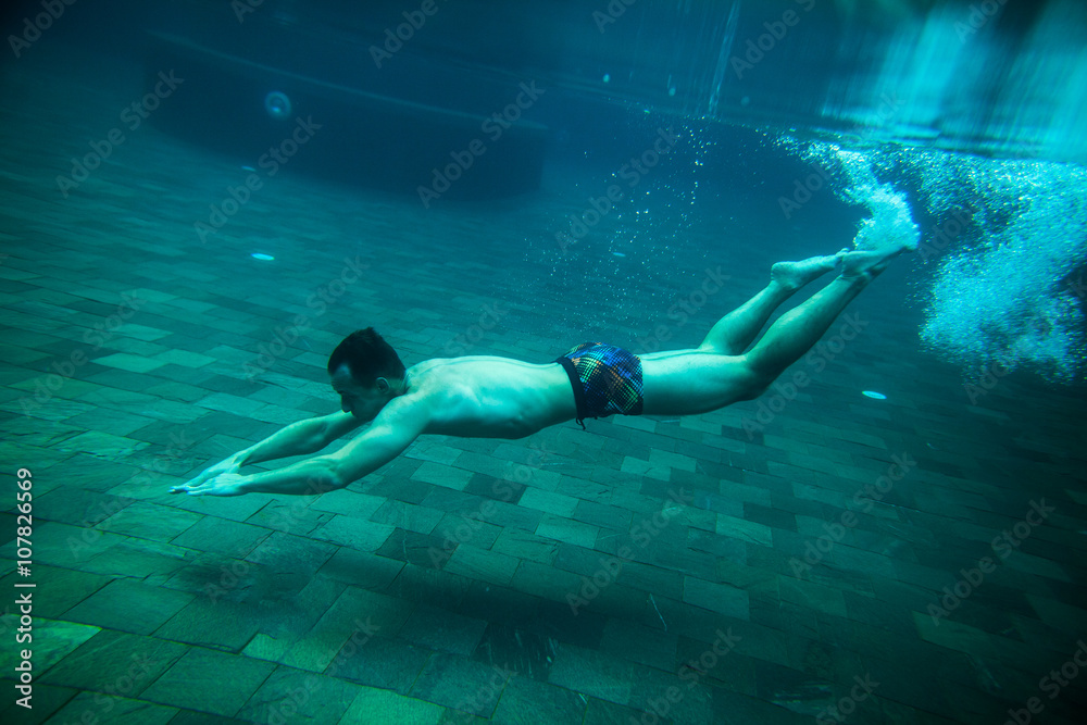 man swim underwater pool