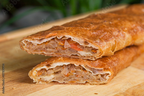 baking of unleavened dough stuffed with cabbage and dried apricots on a wooden board