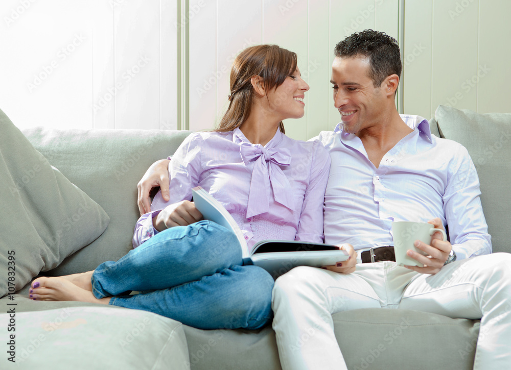 young happy couple relax on couch at home