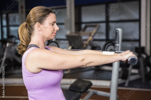 Determined woman lifting dumbbells