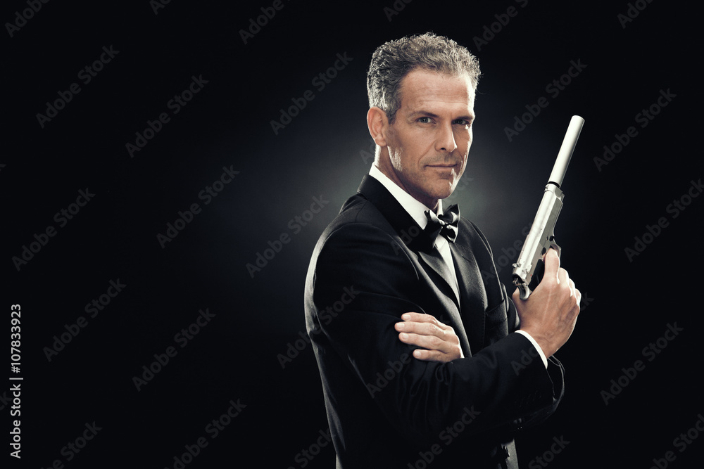 elegant man with bow tie and gun isolated on black elegant man with bow tie and gun isolated on black