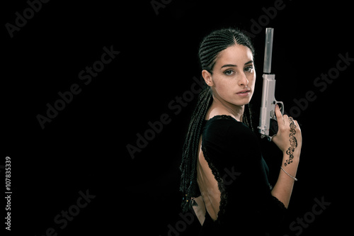 Beautiful dread young woman with gun portrait isolated on black