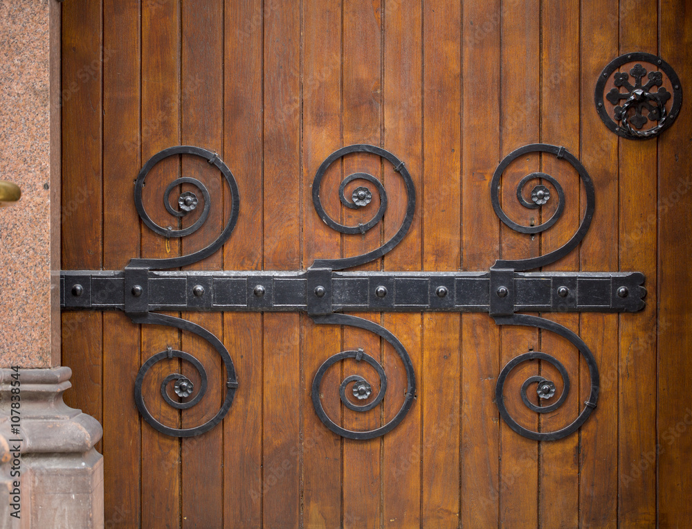 Ornate Door. A beautiful old huge wooden door has ornate metal patterns on it that are used to hold the door together. Ornate Door. A beautiful old huge wooden door has ornate metal patterns on it that are used to hold the door together.