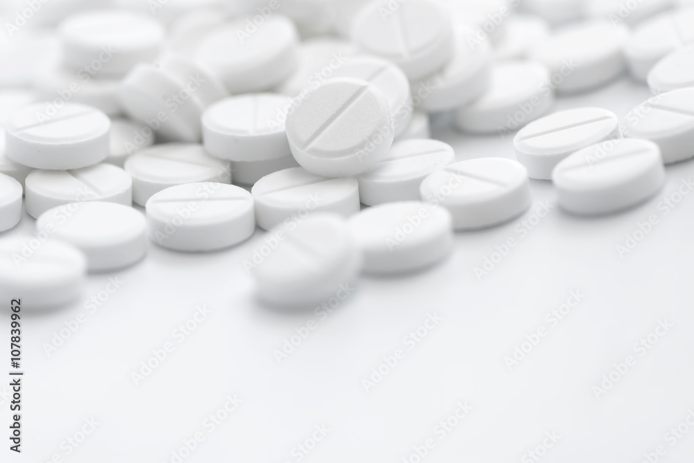 Pile of white pills in closeup on white background