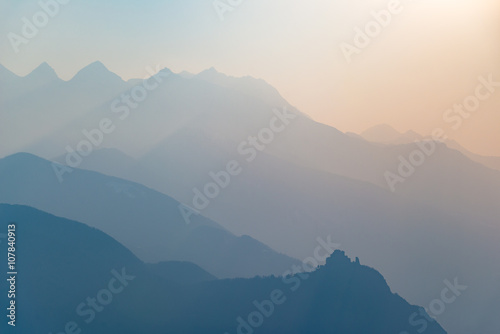 Blue toned mountain silhouette and abbey profile at sunset