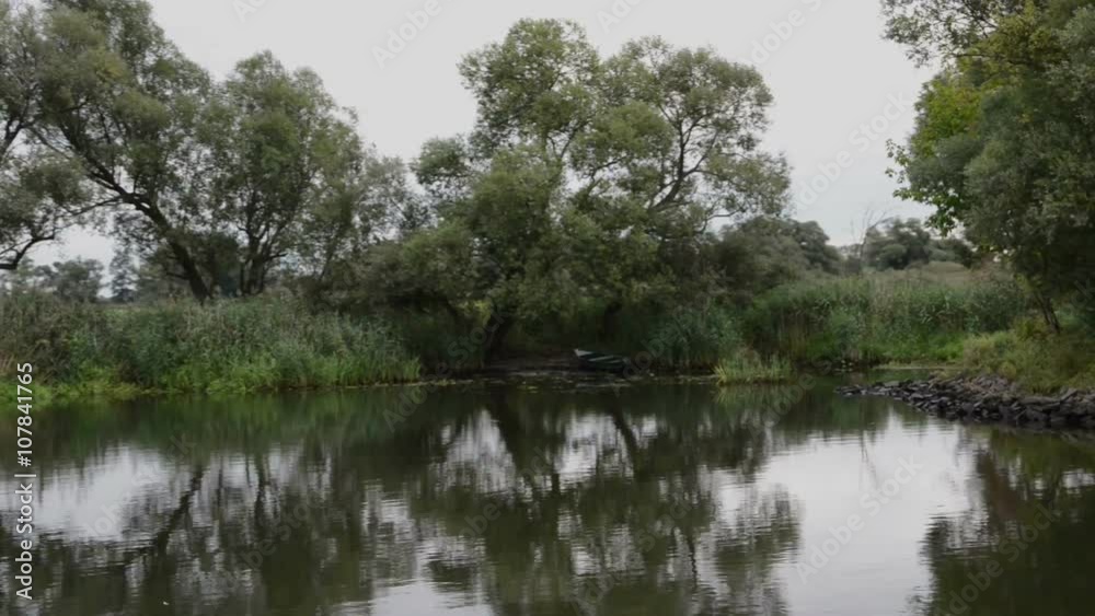 driving with boat along havel river. typical landscape with meadows and willow tries. Havelland region. (Germany) driving with boat along havel river. typical landscape with meadows and willow tries. Havelland region. (Germany)