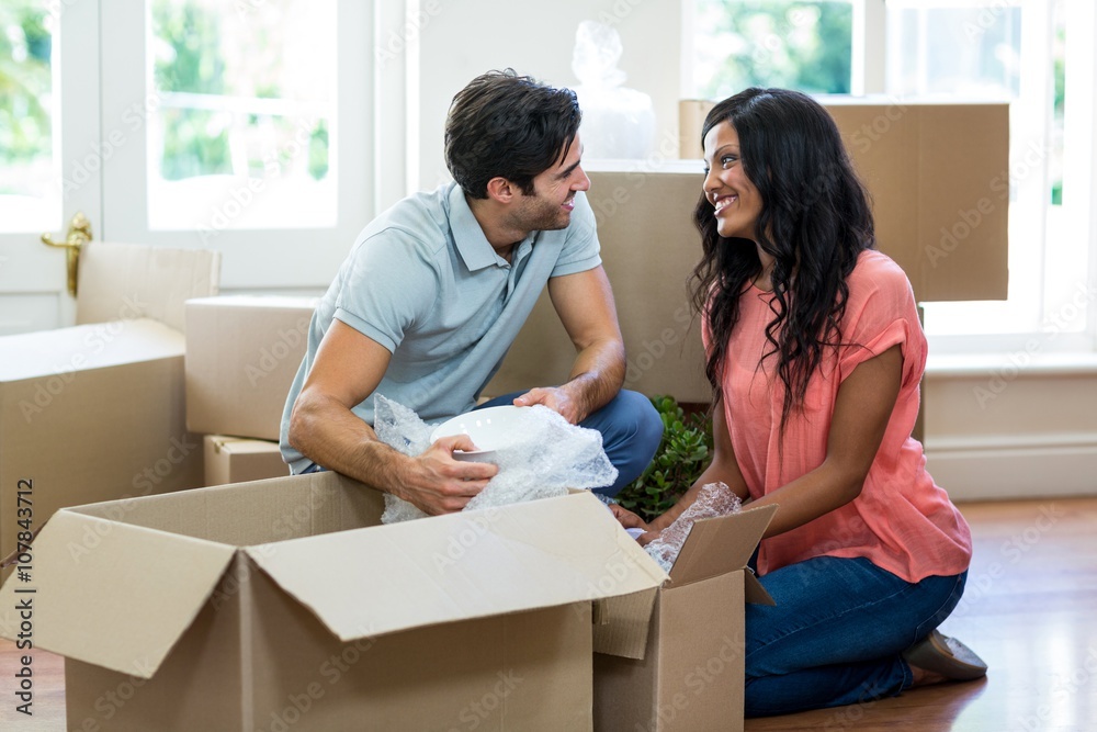 Young couple unpacking carton boxes in their new house Young couple unpacking carton boxes in their new house