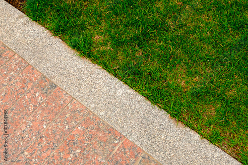Old granite pavement and grass in garden decorative texture, line dividing nature and civilisation, concept