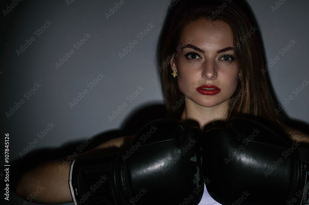Young beautiful sexy boxer woman over grey background