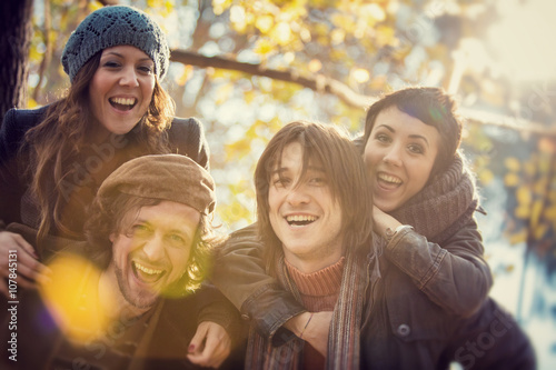 group of Friends having fun at the park  in autumn