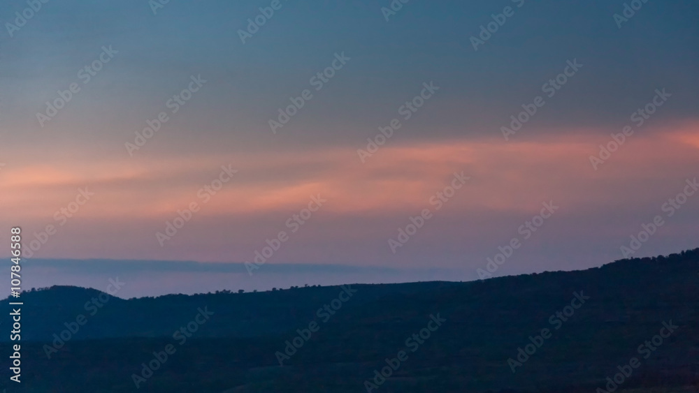 Panoramic view of huge Ngorongoro caldera (extinct volcano crater) against evening glow background at dusk. Great Rift Valley, Tanzania, East Africa.