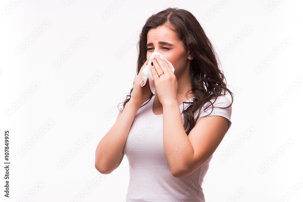Sick woman with flu and fever blowing nose in tissue isolated over white background.