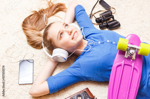Tablou pe pânză Dreaming cheerful teenage girl lying on the floor