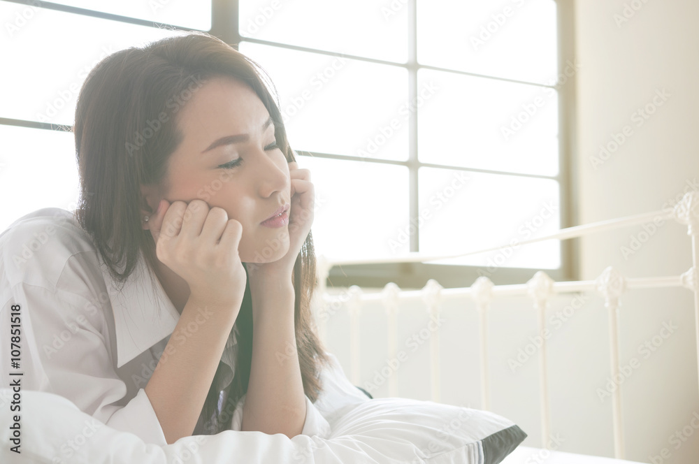 Asian beautiful woman relaxing and thinking on her bed. Asian beautiful woman relaxing and thinking on her bed.