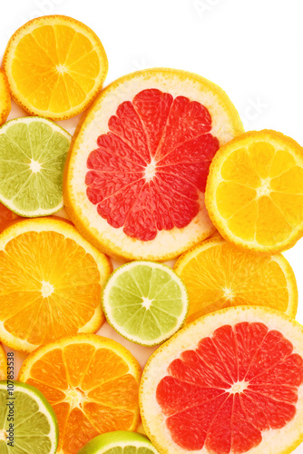Surface covered with citrus sliced fruits over white isolated background