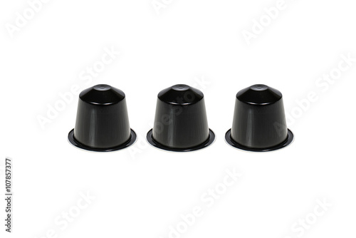Tre capsule di caffè di colore nero su sfondo bianco photo