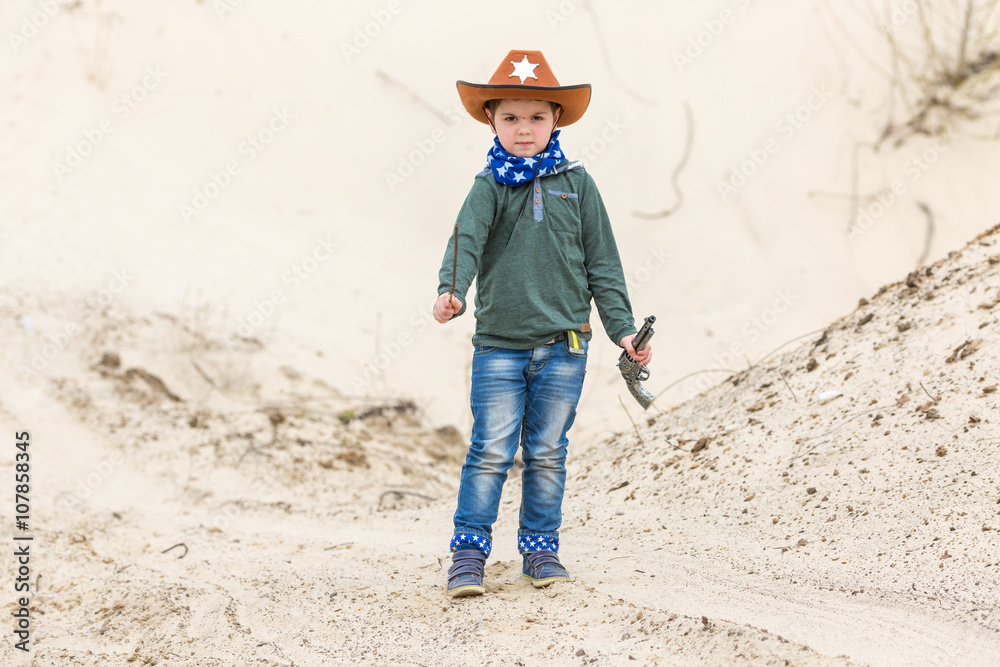 boy in a sheriff hat with a gun