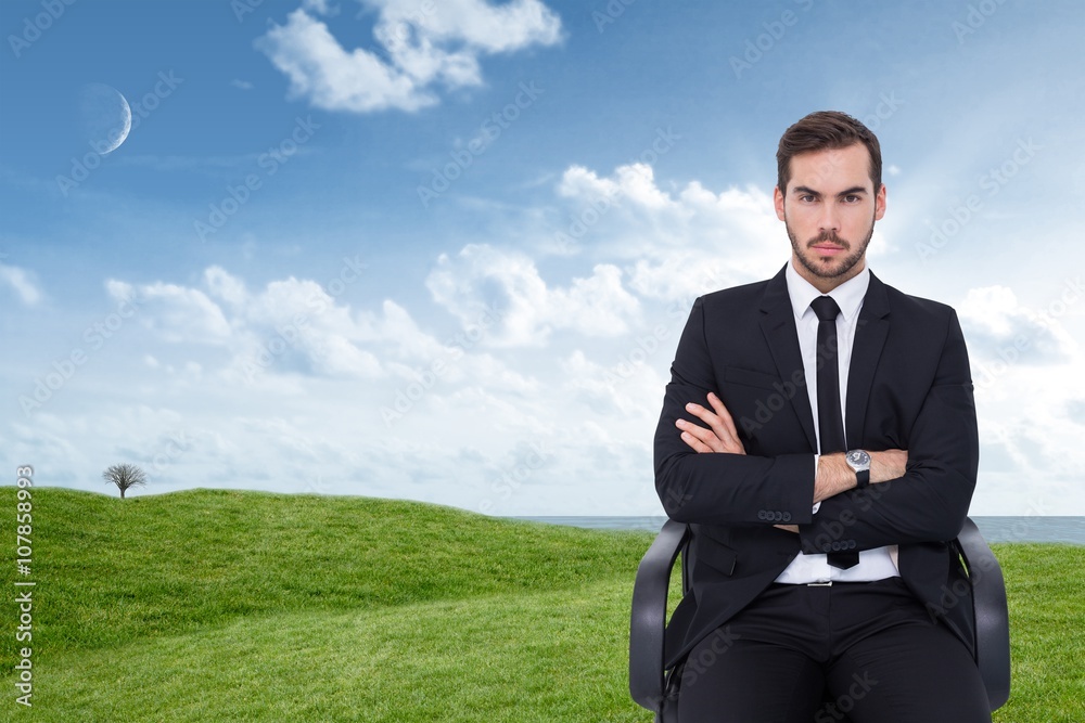 Composite image of serious businessman sitting with arms crossed Composite image of serious businessman sitting with arms crossed