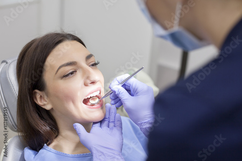 Beautiful woman patient having dental treatment at dentist s office. Woman visiting her dentist