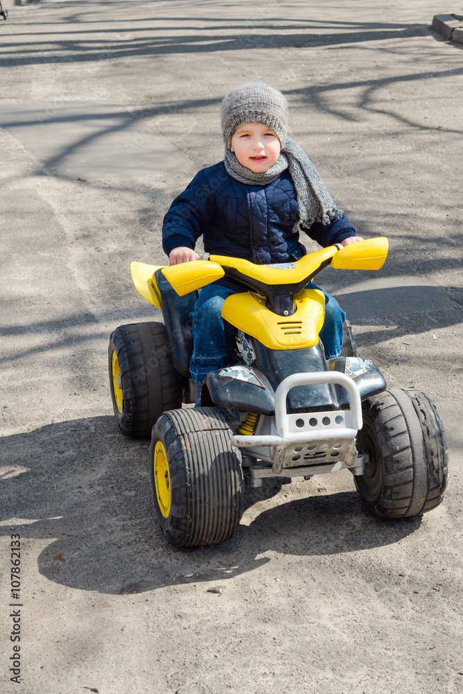 Little preschool boy driving big toy car, playing and having fun, outdoors. Little racer playing in the park.