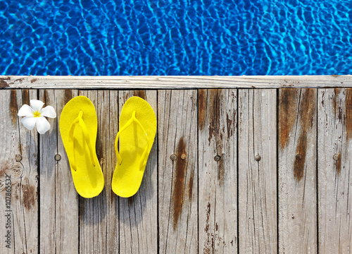 Flip-flops by a swimming pool