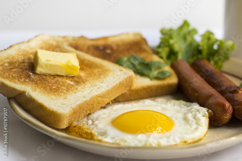 healthy breakfast fried egg yellow yolk, toast bread, sausage, vegetable in morning, delicious sandwich diet lunch