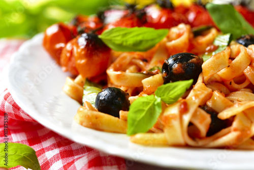 Pasta in tomato sauce with olives,basil and grilled cherry tomat