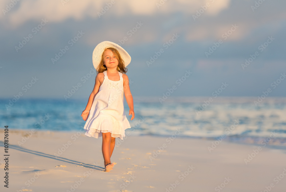 Little girl walking on beautiful ocean beach