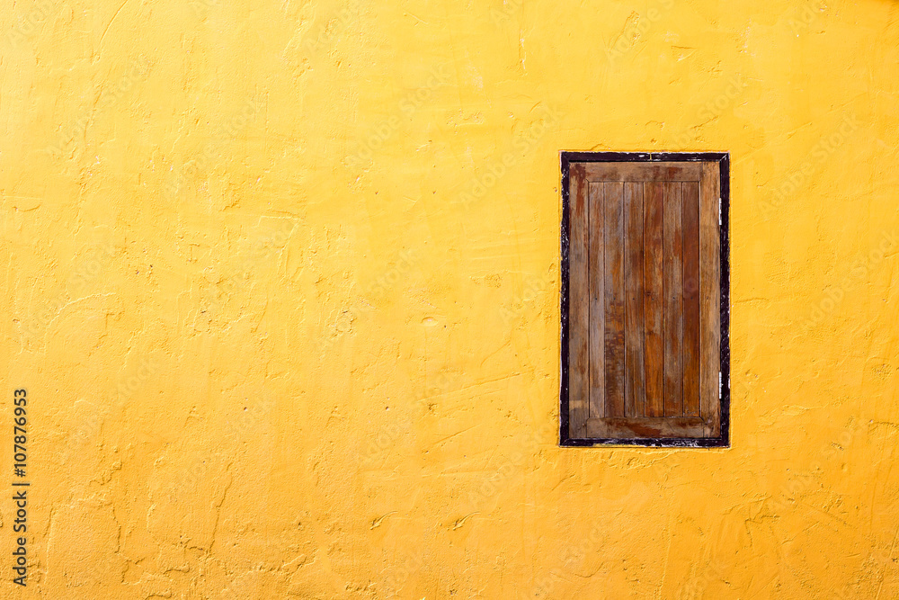 Grunge wood window on bright orange concrete wall. Grunge wood window on bright orange concrete wall.
