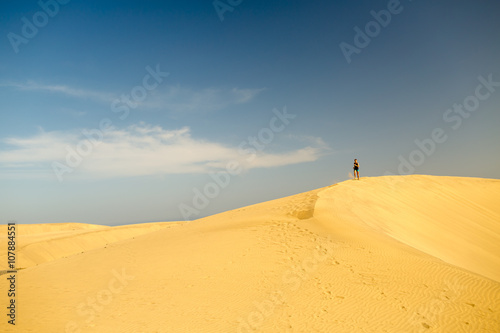 Young woman running on sand desert dunes