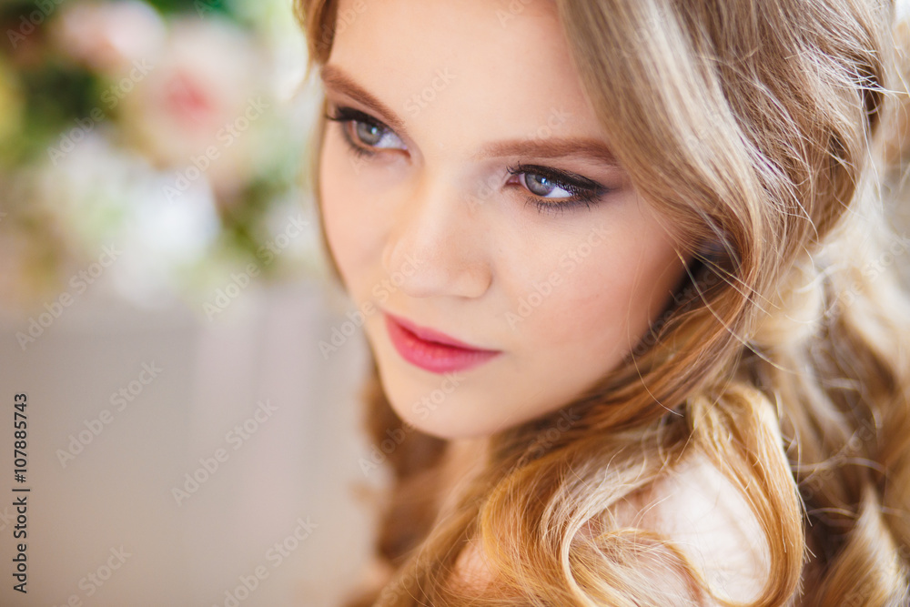 Fototapeta premium Portrait of pretty young girl in a nice dress and long blonde hair in gorgeous interior