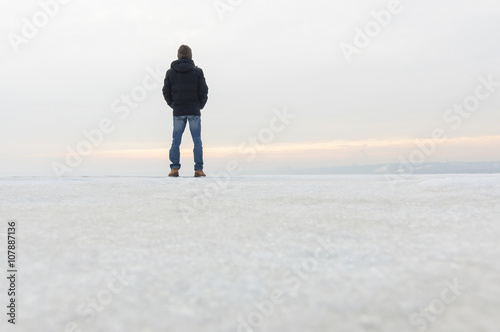 Back view of man standing on snow and watching nature