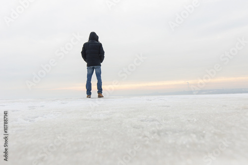 Back view of man standing on snow and watching nature