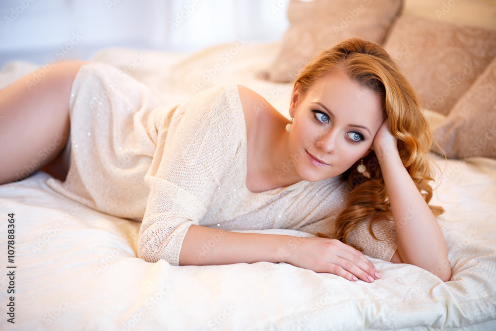 Young beautiful woman in a warm pullover in a light bedroom in a morning. Close up portrait, blue eyes and natural makeup Young beautiful woman in a warm pullover in a light bedroom in a morning. Close up portrait, blue eyes and natural makeup