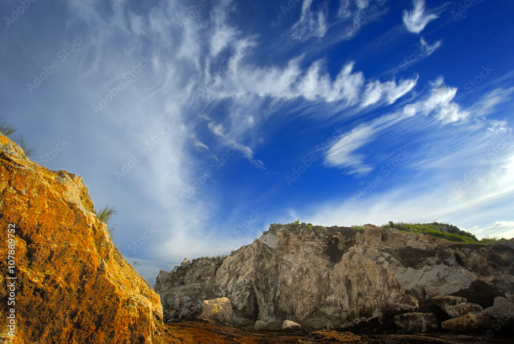 Obraz premium Title : Yellow Rock and Cloud Formation Description : Beautiful landscape of cloud formation over yellow rock makes combination of blue and yellow colors