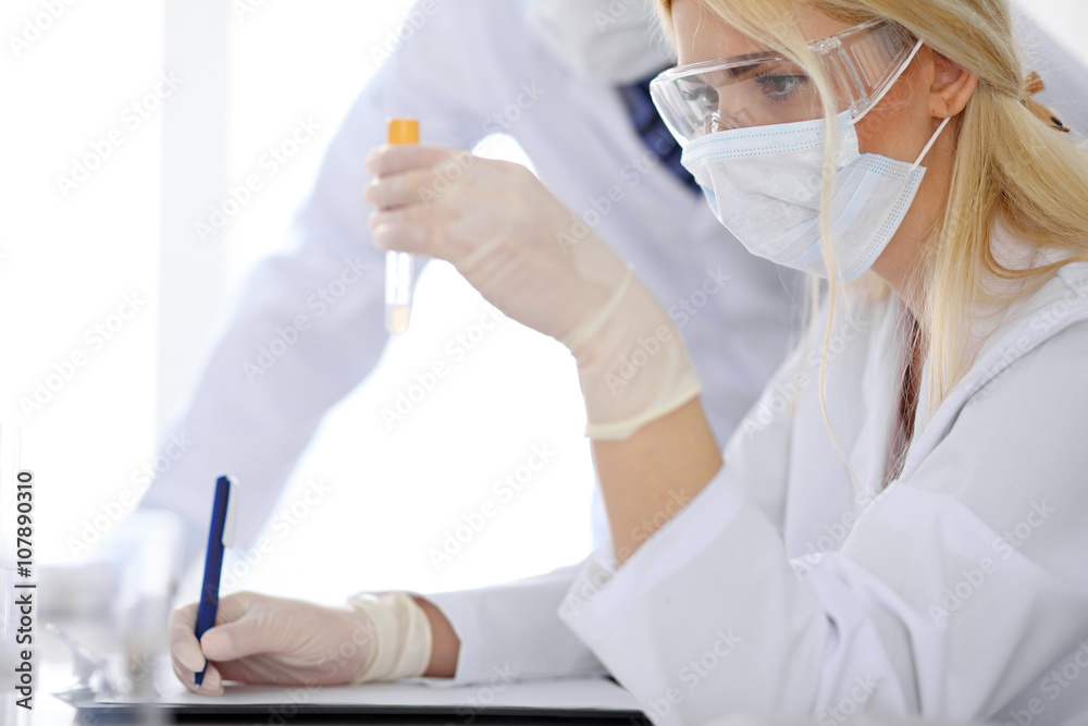 Scientific research team with clear solution in laboratory Scientific research team with clear solution in laboratory