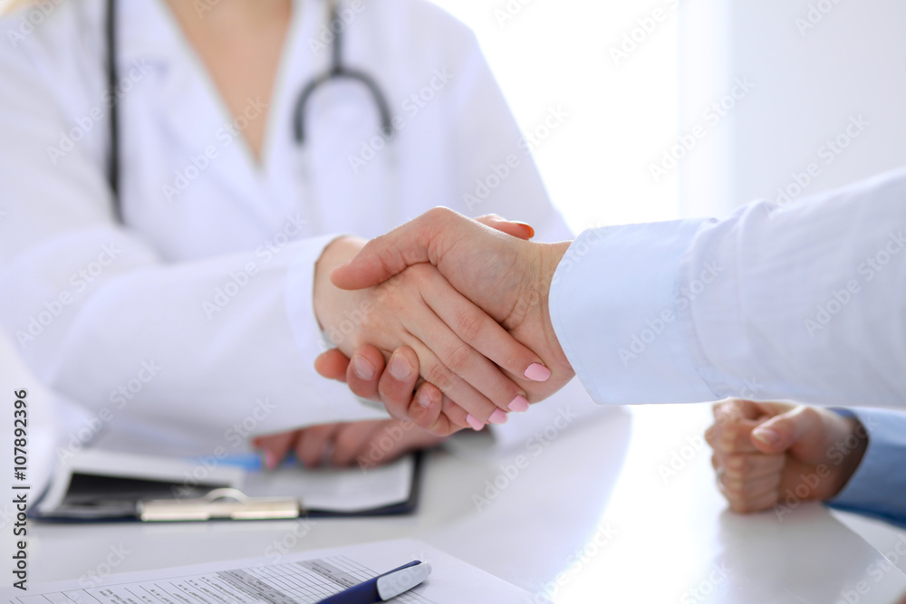 Doctor and patient handshaking. Hands close-up Doctor and patient handshaking. Hands close-up