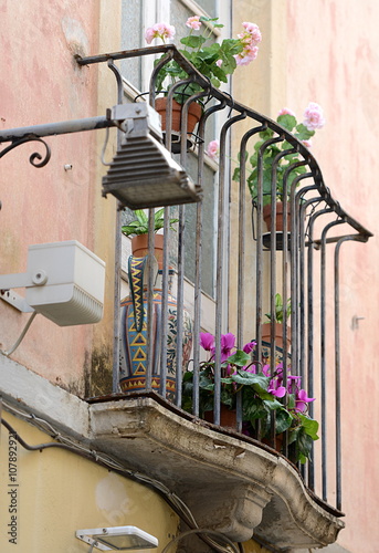 Fototapeta Naklejka Na Ścianę i Meble -  géraniums sur un vieux balcon sicilien