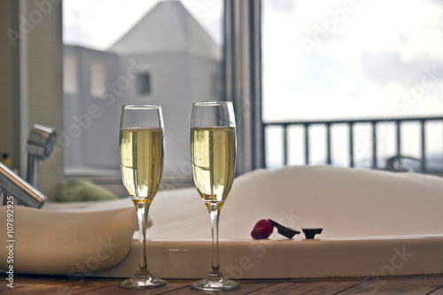 Two glasses of champagne near jacuzzi with strawberry and chocolate
