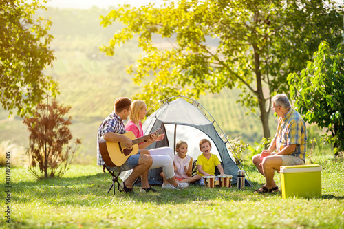 happy parent and children enjoying camping