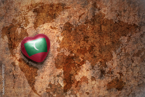 heart with national flag of maldives on a vintage world map crack paper background.