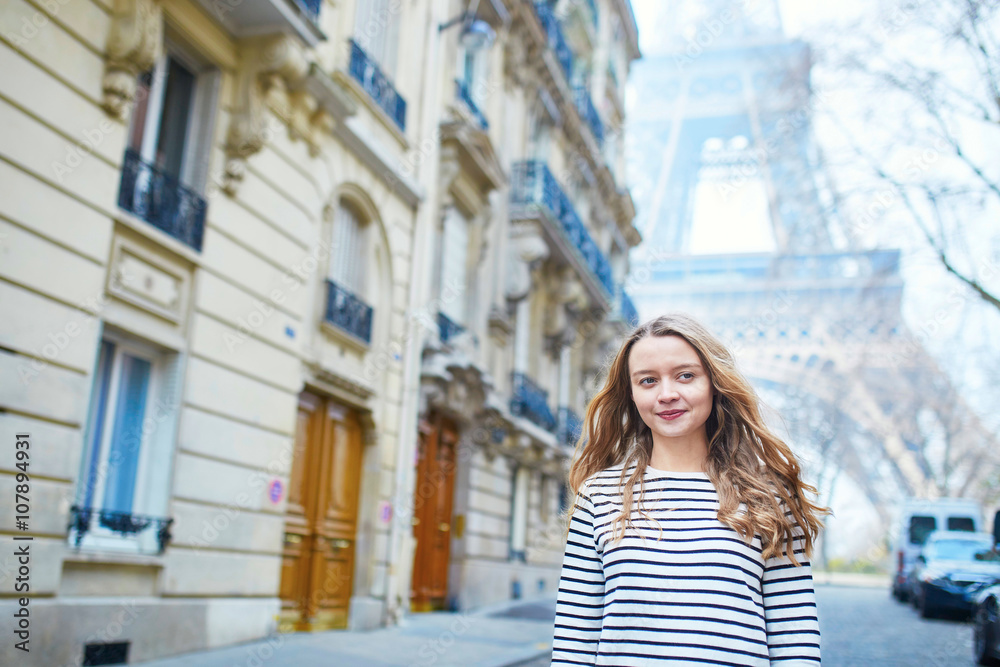 Fototapeta premium Young girl near the Eiffel tower, in Paris